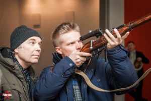 Посетители выставки Выстрел рассматривают снайперскую винтовку Мосина